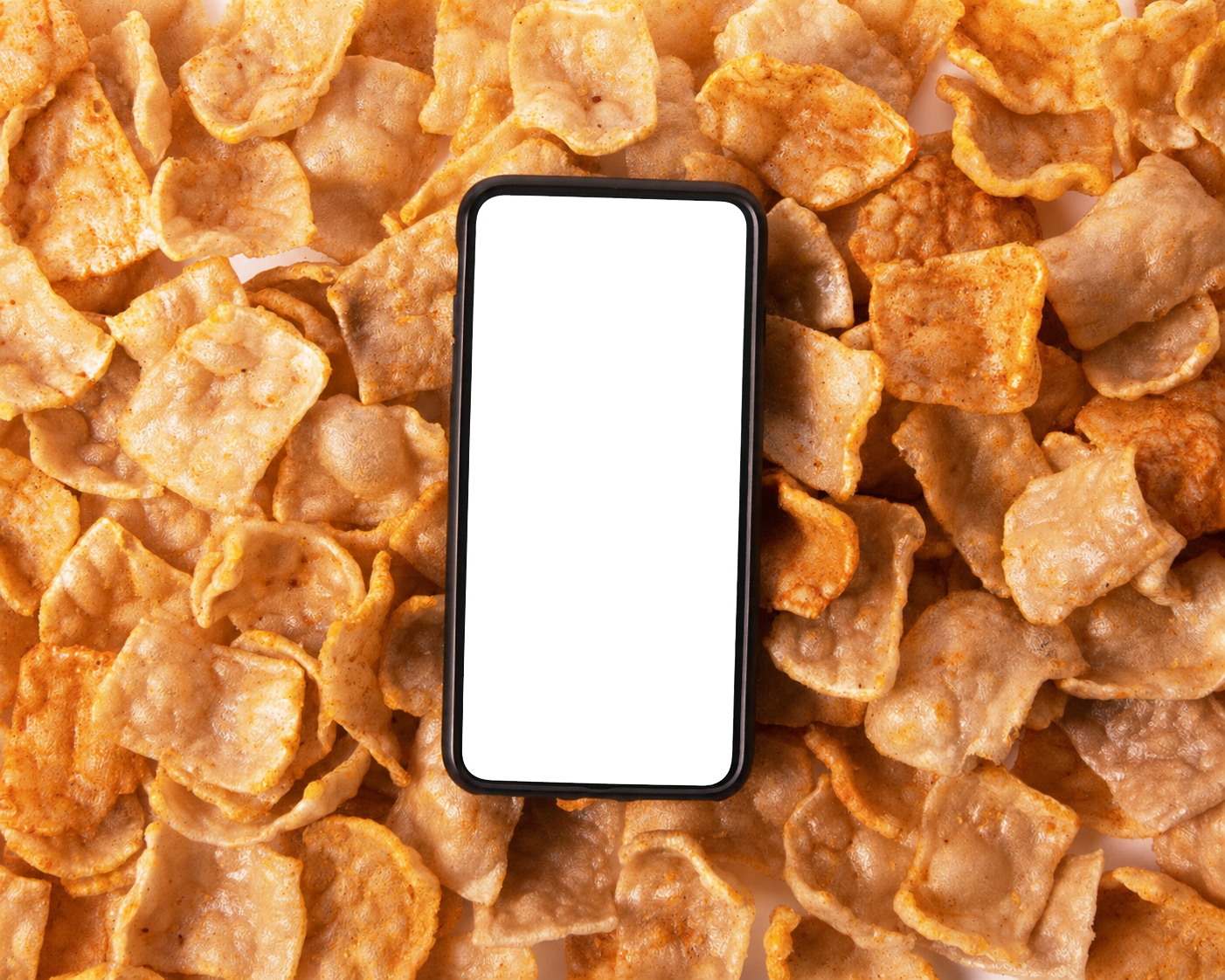 A phone resting on a bed of Snacklins crisps, displaying the Salt & Riot ad